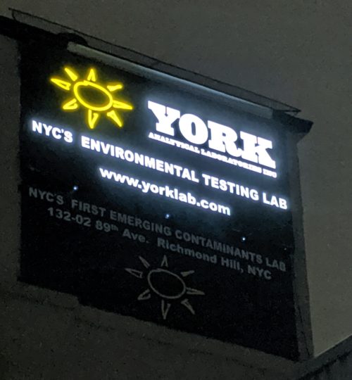 View of the York Analytical Laboratories Richmond Hills NY sign at night