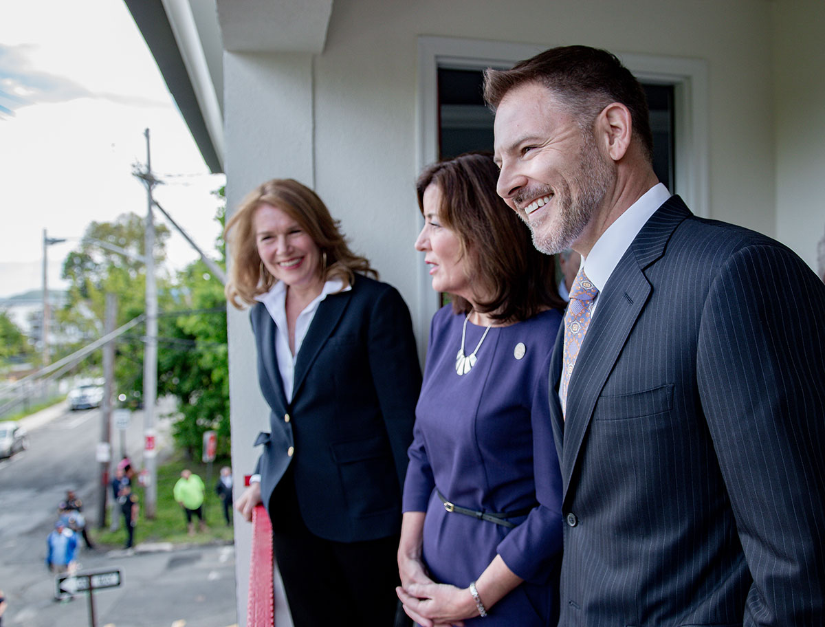 Three executives from YORK Lab standing on a balcony smiling and looking off into the distance
