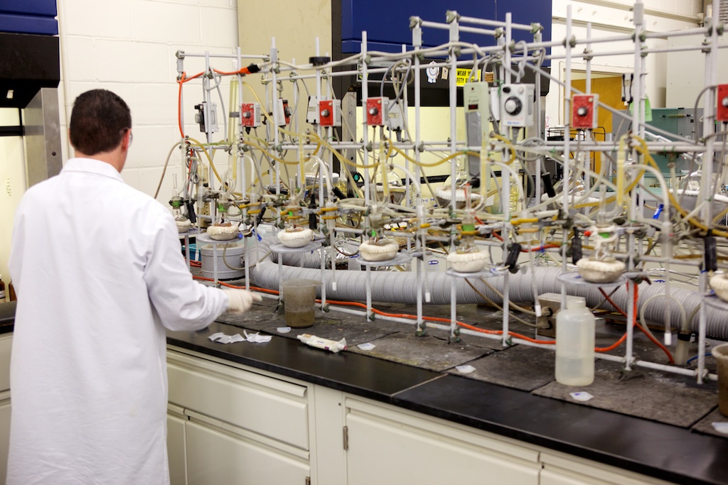 A YORK Labs employee wearing a white lab coat surrounded by equipment while performing a water analysis